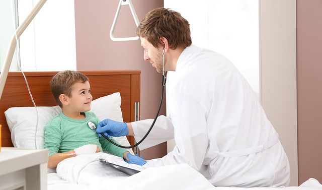 Ein Facharzt für Kinderorthopädie untersucht einen Patienten nach einer Operation.