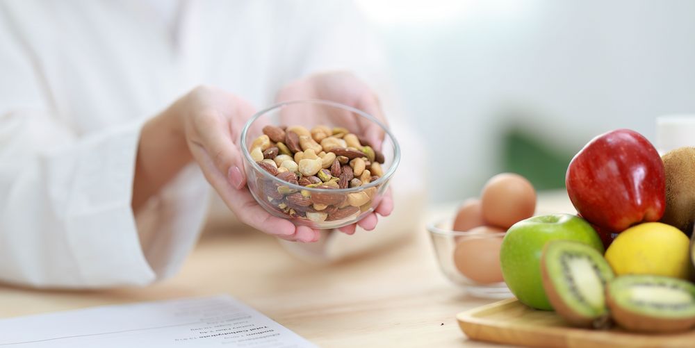 Eine Diätassistentin zeigt eine sinnvolle Portion Essen als Teil einer Ernährungstherapie für Adipositas. 