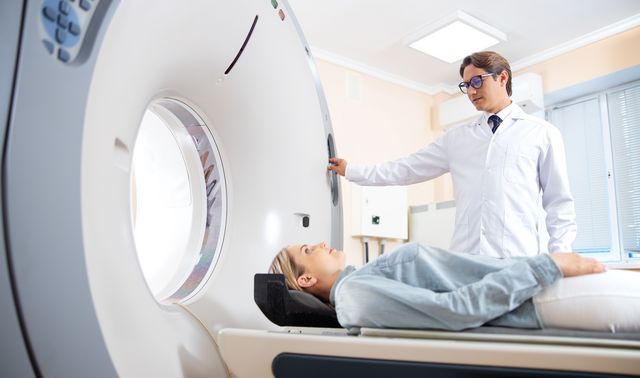 Ein Arzt untersucht eine Patientin mittels CT-Scan vor der Mikrowellenablation ihres Tumors.