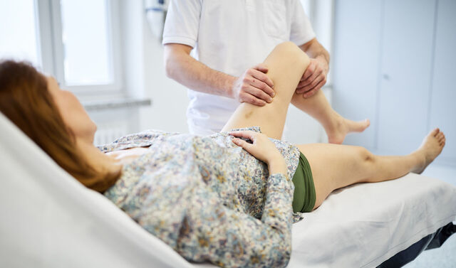 Ein Mitarbeiter der Orthopädie bei einer Untersuchung des Knies.