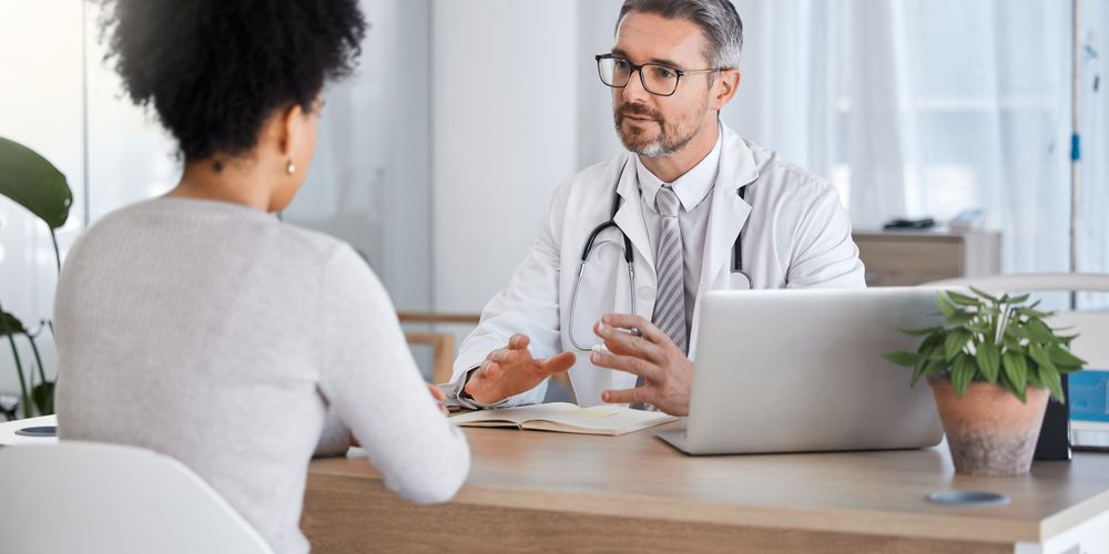 Ein Arzt berät eine Patientin zur Behandlung ihres Blinddarms.