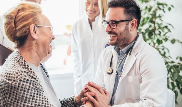 Ein Arzt spricht mit einer Patientin über Ergebnisse der Untersuchung und ob das Risiko eines Aneurysmas besteht.