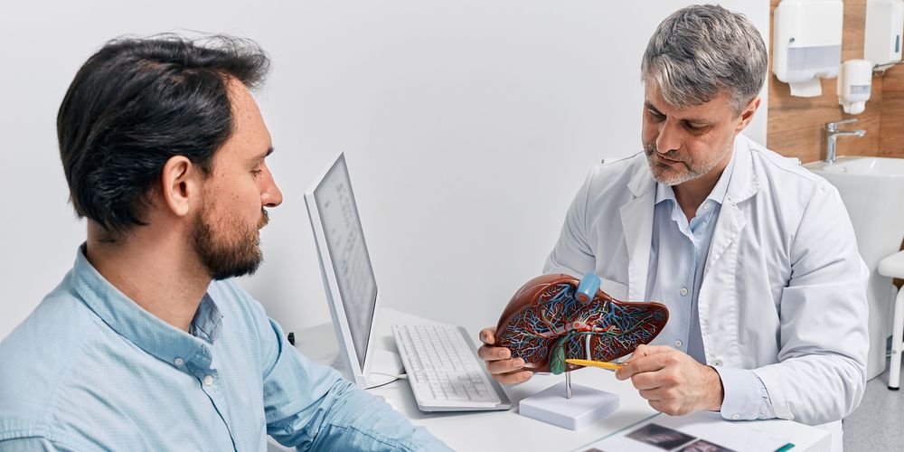 Ein Arzt berät einen Patienten zur Behandlung seiner Gallenblasenentzündung.