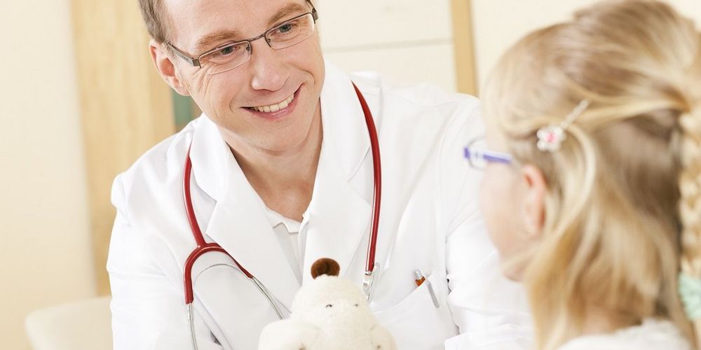 Ein Facharzt für Kinderorthopädie bei der Behandlung eines Kindes.