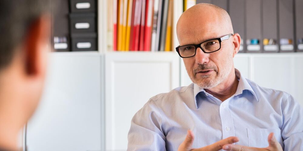 Ein Arzt auf dem Spezialgebiet der Psychosomatik im Gespräch mit einem Patienten.