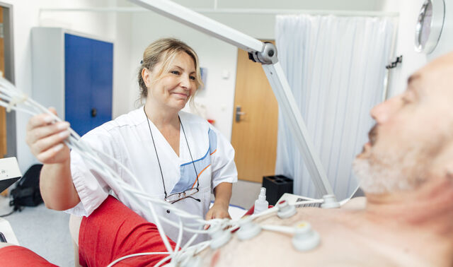 Eine Mitarbeiterin der onkologischen Reha behandelt einen Patienten. 