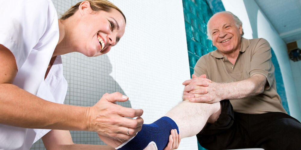 Was gehört zu den Aufgaben eines Orthopäden? Eine Mitarbeiterin der Orthopädie untersucht einen Patienten.