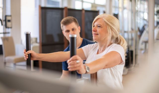 Ein Mitarbeiter und eine Patientin beim Funktionstraining im Rahmen des Rehasports.