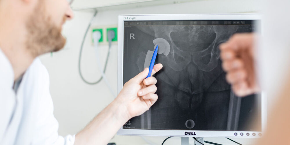 Fachbereich Orthopädie Das Bild zeigt einen Arzt bei der orthopädischen Untersuchung mit einem Patienten.