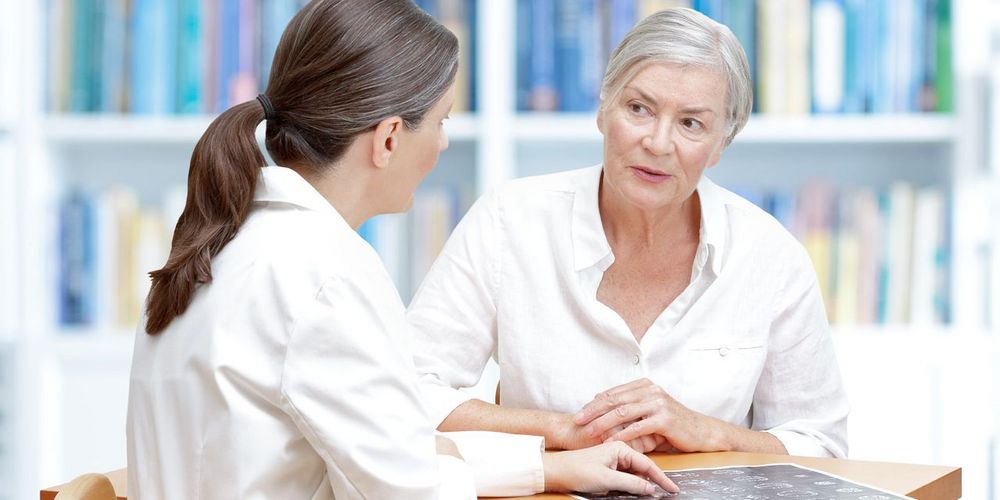 Eine Onkologin erklärt einer Patientin im Tumorzentrum das Verfahren der lokalen Tumortherapie.