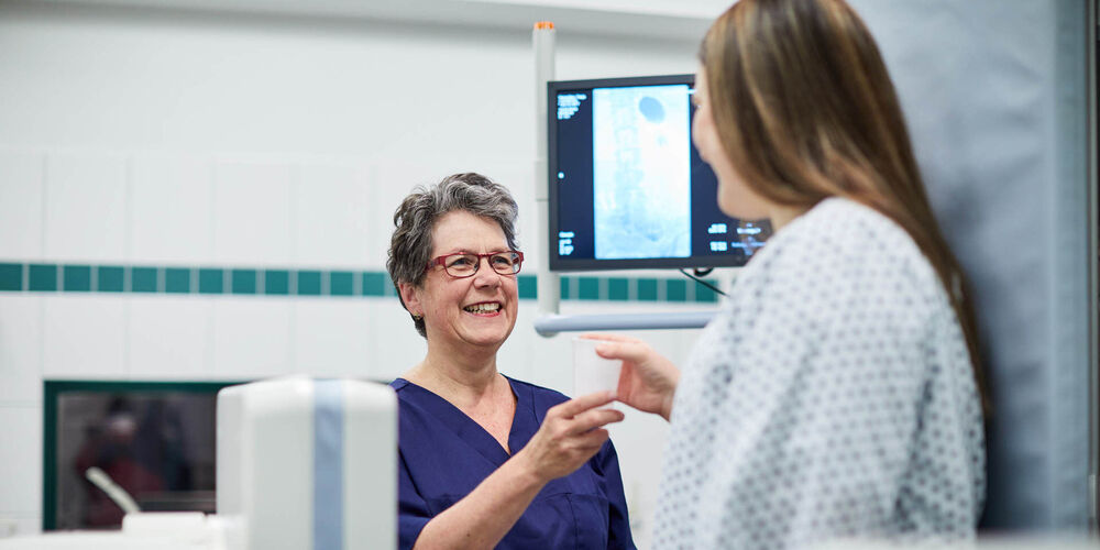 Eine Mitarbeiterin der Uroynäkologie bereitet eine Untersuchung für eine Patientin vor.